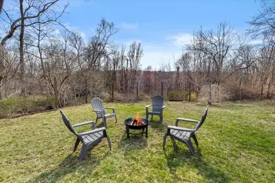 a group of chairs sitting around a fire pit at Cozy Farmhouse - Fireplace, Backyard, BBQ, Games - 3 MIN TO CAMELBACK in Tannersville