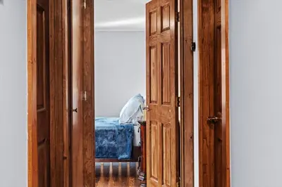 an open wooden door in a room with a bed at Cozy Farmhouse - Fireplace, Backyard, BBQ, Games - 3 MIN TO CAMELBACK in Tannersville