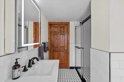 a bathroom with a sink and a wooden door at Cozy Farmhouse - Fireplace, Backyard, BBQ, Games - 3 MIN TO CAMELBACK in Tannersville