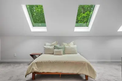 a bed in a white room with two windows at Luxury Princeton Estate Pool, Hot Tub, Sleeps 20 in Princeton