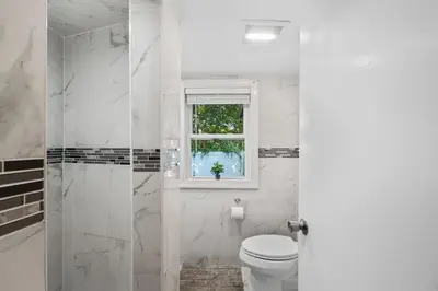 a white bathroom with a toilet and a window at 3BR Home 2 Baths Bonus Room, Minutes to NYC in Hackensack