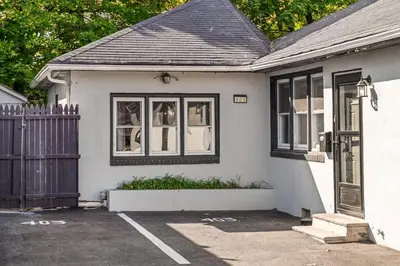 a white house with black windows and a gate at 3BR Home 2 Baths Bonus Room, Minutes to NYC in Hackensack