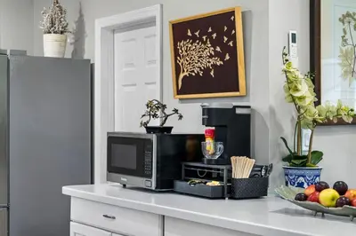 a microwave on a counter with a bowl of fruit at 4BR Home Minutes to NYC Time Square in Teaneck