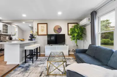 a living room with a blue couch and a kitchen at 4BR Home Minutes to NYC Time Square in Teaneck