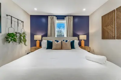 a bedroom with a large white bed with blue walls at Emerald Luxe Retreat Lake Hot Tub Sauna in Long Pond