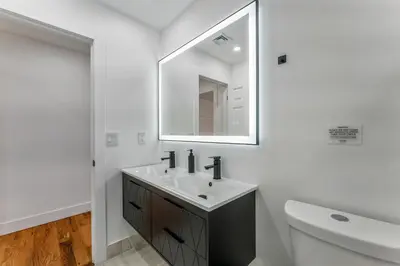 a white bathroom with a sink and a mirror at Emerald Luxe Retreat Lake Hot Tub Sauna in Long Pond