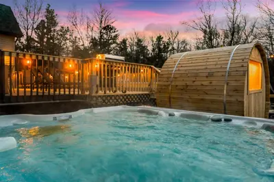 a hot tub in a backyard with a wooden fence at Emerald Luxe Retreat Lake Hot Tub Sauna in Long Pond