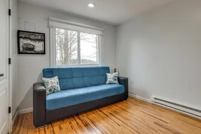 a blue couch in a room with a window at Waterfront Arrowhead Lake Retreat with Resort Perks! in Pocono Lake