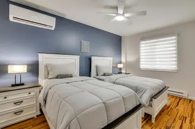 two beds in a bedroom with a blue wall at Waterfront Arrowhead Lake Retreat with Resort Perks! in Pocono Lake