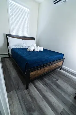 a bed with two white towels on it in a room at Cozy Urban Oasis Near NYC in West New York