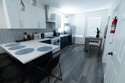 a kitchen with white cabinets and a counter top at Cozy Urban Oasis Near NYC in West New York