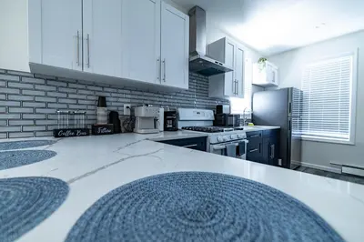a kitchen with white cabinets and a white counter top at Cozy Urban Oasis Near NYC in West New York