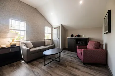 a living room with a couch and a chair and a table at Normandy Farm Hotel & Conference Center in Blue Bell
