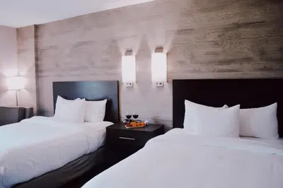 two beds in a hotel room with white pillows at Normandy Farm Hotel & Conference Center in Blue Bell