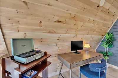 a room with a wooden wall with a computer on a desk at Lakefront AFrame, Heated Pool, Spa, Sauna, Theatre in Blakeslee