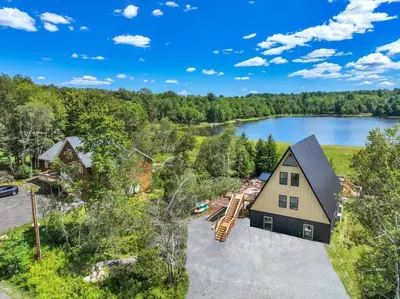 an aerial view of a house with a lake at Lakefront AFrame, Heated Pool, Spa, Sauna, Theatre in Blakeslee