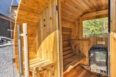 a wooden sauna with a large window at Lakefront AFrame, Heated Pool, Spa, Sauna, Theatre in Blakeslee