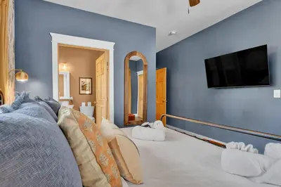a living room with a tv on a blue wall at Golf Sim, Game-Movie Room, Spa, Sauna, Arcade ! in Tobyhanna