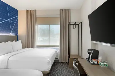 a hotel room with a bed and a desk with a television at Comfort Inn in Staten Island