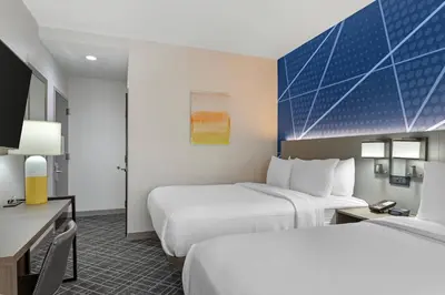 a hotel room with two beds and a desk at Comfort Inn in Staten Island