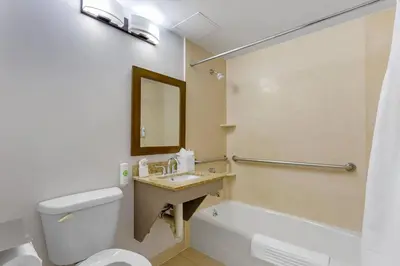 a bathroom with a toilet and a sink and a tub at Comfort Inn in Staten Island