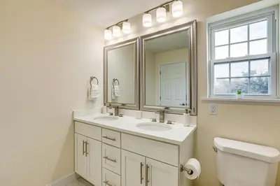 a bathroom with two sinks and a mirror and a toilet at Walk to Keansburg Beach! Family Home with Pool in Keansburg
