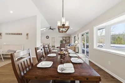 a dining room with a long wooden table and chairs at The Rock Oak Escape in Dingmans Ferry