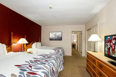 a hotel room with two beds and a flat screen tv at Red Roof Inn & Suites Hazleton in Hazleton