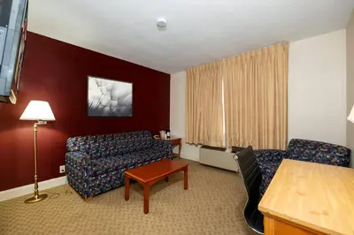a hotel room with a couch and a chair at Red Roof Inn & Suites Hazleton in Hazleton