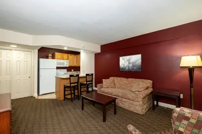 a living room with a couch and a kitchen at Red Roof Inn & Suites Hazleton in Hazleton