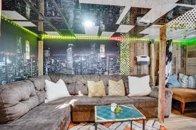a living room with a couch and a city mural at Upper Clinton Hill Studio! Walk to Eats and Shops in Newark