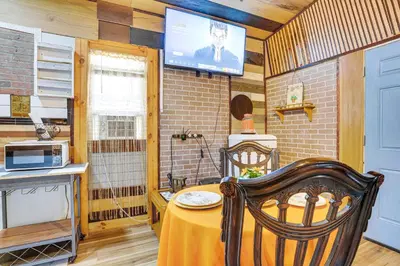 a kitchen with a table and a tv on the wall at Upper Clinton Hill Studio! Walk to Eats and Shops in Newark