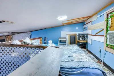a bedroom with a bed and a blue wall at Upper Clinton Hill Studio! Walk to Eats and Shops in Newark