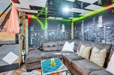 a living room with a couch and a city wall at Upper Clinton Hill Studio! Walk to Eats and Shops in Newark