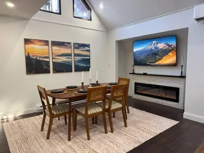 a dining room with a table and chairs and a tv at Mountain View family escape in Albrightsville