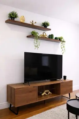 a flat screen tv sitting on top of a wooden entertainment center at Hip NYC Hideaway in Lively East Village in New York