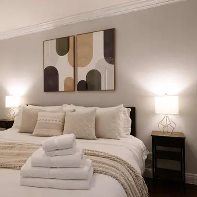 a bedroom with a white bed with two pictures on the wall at Hip NYC Hideaway in Lively East Village in New York
