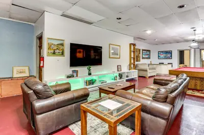 a living room with leather furniture and a flat screen tv at 4 Mi to Mauch Chunk Lake Spacious Apt with Bar! in Summit Hill