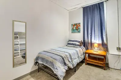 a small bedroom with a bed and a mirror at 4 Mi to Mauch Chunk Lake Spacious Apt with Bar! in Summit Hill