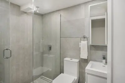 a bathroom with a shower and a toilet and a sink at 22nd Sleek Modern 1BR Gramercy in New York