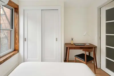 a bedroom with a bed and a desk with a table at 22nd Sleek Modern 1BR Gramercy in New York