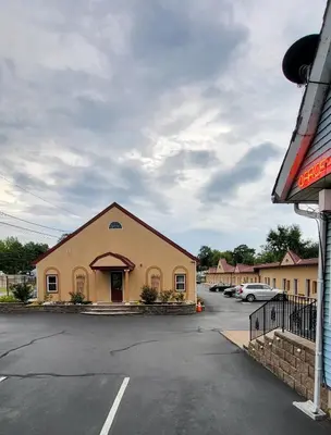 a building in a parking lot with cars parked at Red Bank Inn