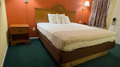 a hotel room with a bed and a night stand at Red Bank Inn