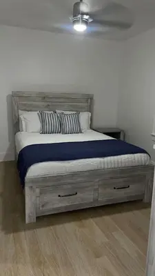 a bed with a wooden headboard in a bedroom at 3 Loft Bedrooms Gazebo Patio Lounge in Roselle