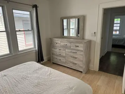 a bedroom with a bed and a dresser with a mirror at 3 Loft Bedrooms Gazebo Patio Lounge in Roselle