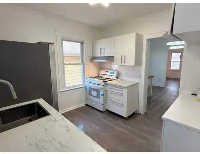 a kitchen with white cabinets and a stove top oven at 3 Loft Bedrooms Gazebo Patio Lounge in Roselle