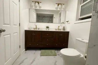 a bathroom with a sink and a toilet and a mirror at 3 Loft Bedrooms Gazebo Patio Lounge in Roselle