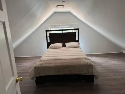 a bedroom with a large bed in a attic at 3 Loft Bedrooms Gazebo Patio Lounge in Roselle