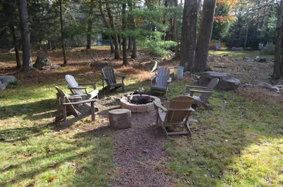 a group of chairs sitting around a fire pit at 4BR Cabin by the Lake with Hot Tub, Game Room, Fire Pit in Lake Harmony