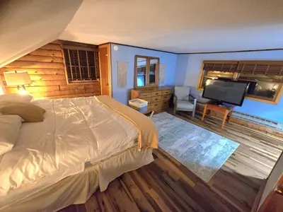 a bedroom with a bed and a flat screen tv at 4BR Cabin by the Lake with Hot Tub, Game Room, Fire Pit in Lake Harmony